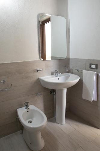 a bathroom with a sink and a toilet and a mirror at Fardella 250 in Trapani
