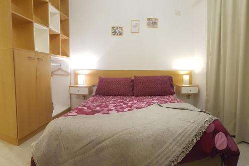 1 dormitorio con 1 cama grande con sábanas moradas en Rent for Days en San Miguel de Tucumán