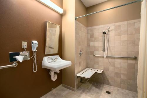 a bathroom with a sink and a phone on the wall at Microtel Inn & Suites in Sidney