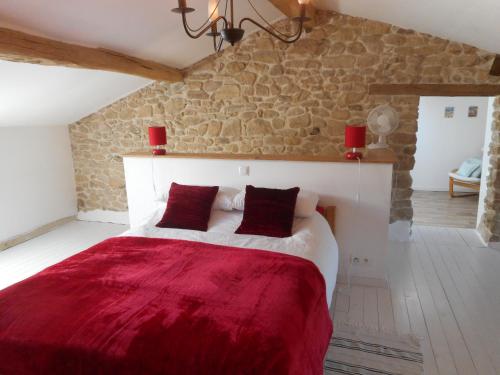 ein Schlafzimmer mit einem großen Bett mit einer roten Decke in der Unterkunft 38 Friaudour in Saint-Pardoux