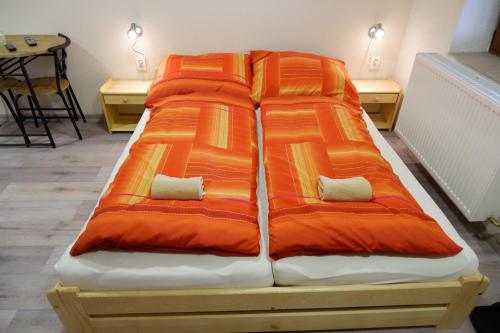 ホルニー・プラナーにあるApartments Habertのベッド(オレンジと白の枕付)