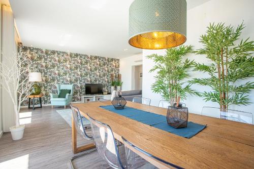 a dining room with a wooden table and plants at T3 Aleluia in Nazaré
