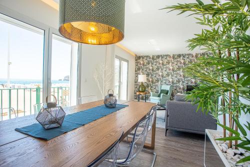 a dining room with a large wooden table with chairs at T3 Aleluia in Nazaré