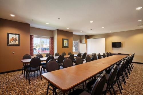 a conference room with tables and chairs and a whiteboard at Microtel Inn & Suites in Sidney