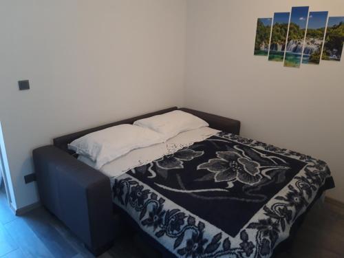 - un lit avec une couverture noire et blanche dans l'établissement Apartmani Ponistra, à Šibenik