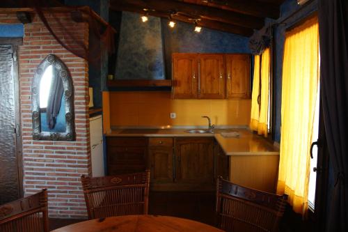 uma cozinha com armários de madeira, um lavatório e uma mesa em Agroturismo Maddiola em San Sebastián