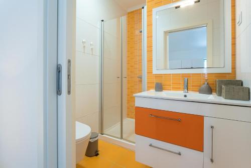 uma casa de banho com um WC, um lavatório e um chuveiro em T3 Abegoarias Filipe do Canto na Nazaré