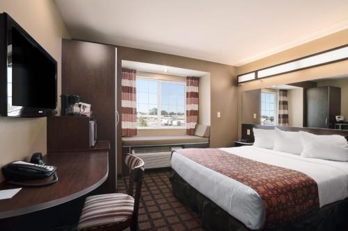 a hotel room with a bed and a television at Microtel Inn & Suites in Sidney