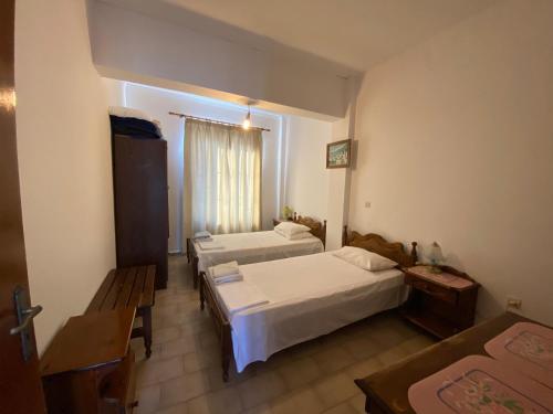 Habitación de hotel con 2 camas y ventana en Blue Sky Apartments, en Karpathos