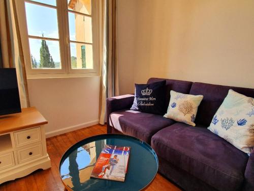 a living room with a purple couch and a glass table at Apartment Picasso in großem Park mit geheiztem Pool in Châteauneuf