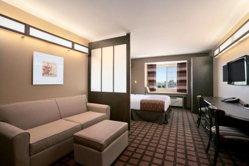 a hotel room with a couch and a bed and a desk at Microtel Inn & Suites in Sidney