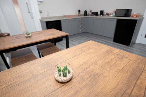 a wooden table with a bowl with a cactus on it at Lynwood House in Southport