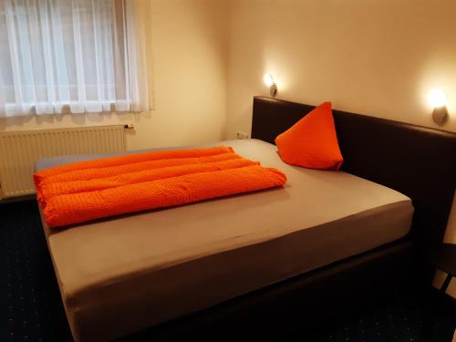 マイヤーホーフェンにあるFerienwohnung Tuxerstraßeのベッド1台(上にオレンジの枕2つ付)
