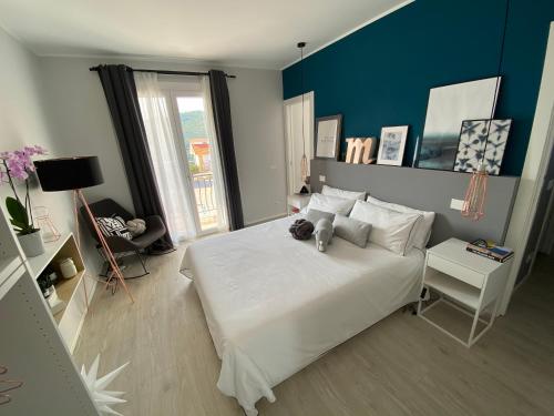 Un dormitorio con una cama blanca con un osito de peluche. en Leono’, en Seborga