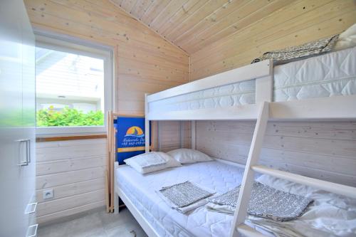 a bedroom with bunk beds in a wooden cabin at Domki Nadmorska Oaza nad morzem i jeziorem in Jezierzany