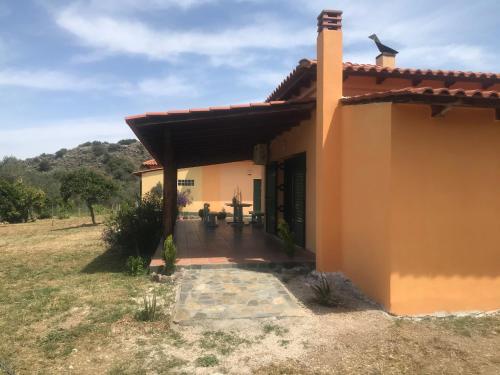 a house with a porch in a field at Country house in Galatas