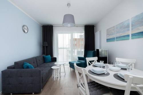 a living room with a table and a couch at Symphony Baltica Towers Apartamenty in Gdańsk