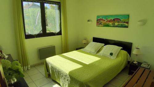 a bedroom with a green bed and a window at Appartement 3 étoiles avec jardin privatif et parking in Aix-les-Bains