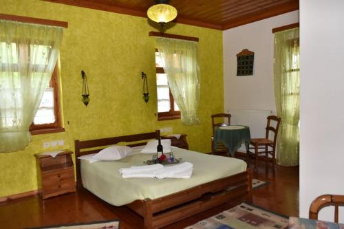 a bedroom with a bed in a room with yellow walls at Hotel Faraggi in Tsepelovo