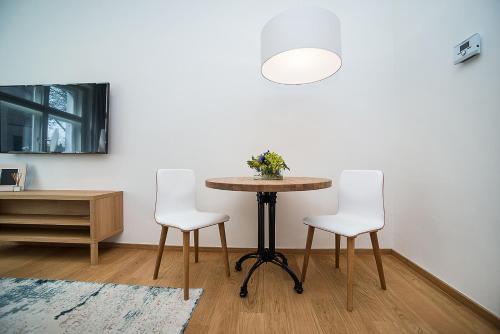 een tafel en twee witte stoelen in een kamer bij Charming apartment in famous area in Praag