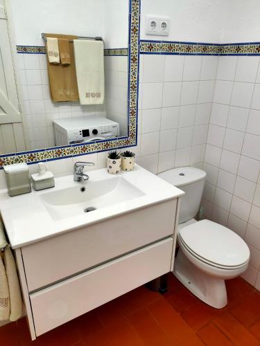 a bathroom with a white sink and a toilet at Studio Pedras d'el Rei in Santa Luzia