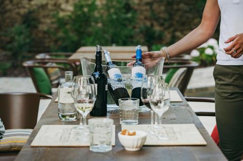 Ventozelo Hotel & Quinta في Ervedosa do Douro: طاولة عليها زجاجات النبيذ والاكواب