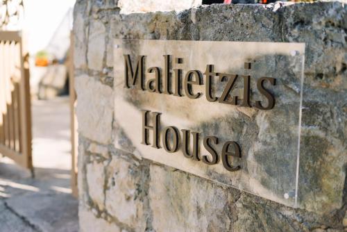 un cartello per una casa walhalla su un muro di pietra di Malietzis House a Pano Arodes