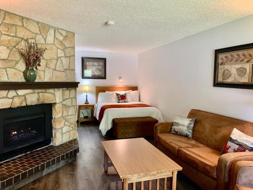 a living room with a bed and a fireplace at Schott's Lake Conference & Resort in Sundre