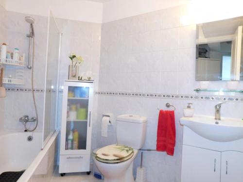 a white bathroom with a toilet and a sink at Beautiful Regina gardens in Paphos City