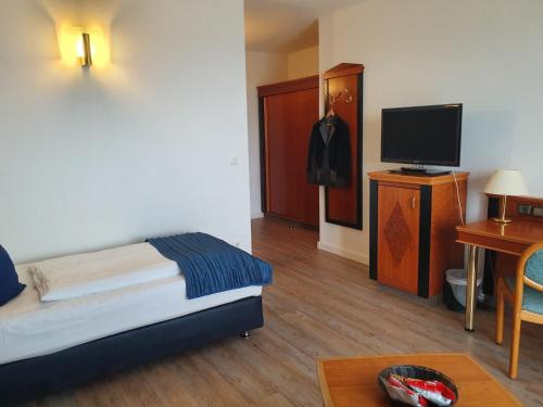 a room with a bed and a television and a table at Hotel Novum in Hinte