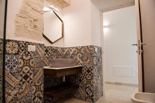 a bathroom with a sink and a mirror at Trulli Pietraviva with Pool in Santa Lucia