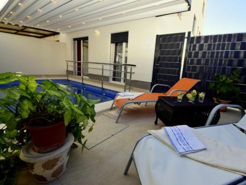 eine Terrasse mit einem Pool, Stühlen und Pflanzen in der Unterkunft Apartment Marin by Interhome in Trogir