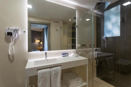 a bathroom with a sink and a shower and a mirror at Hotel Lima - Adults Recommended in Marbella