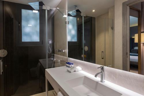 a bathroom with a sink and a large mirror at Hotel Lima - Adults Recommended in Marbella