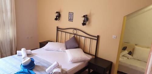 a small bedroom with a bed and a mirror at Ilios Apartments in Poros