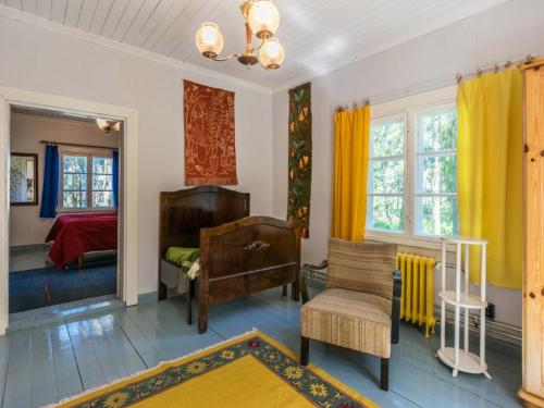 een slaapkamer met gele gordijnen en een bed en een stoel bij Holiday Home Piispasen torppa by Interhome 
