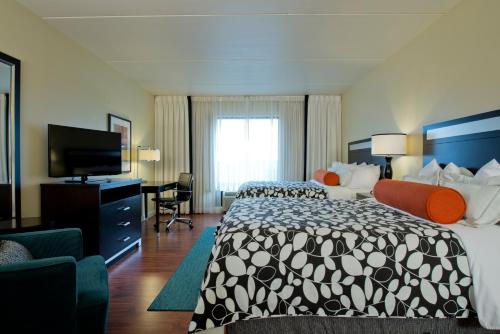ein Hotelzimmer mit einem Bett und einem Flachbild-TV in der Unterkunft Hotel Indigo Atlanta Airport College Park, an IHG Hotel in Atlanta