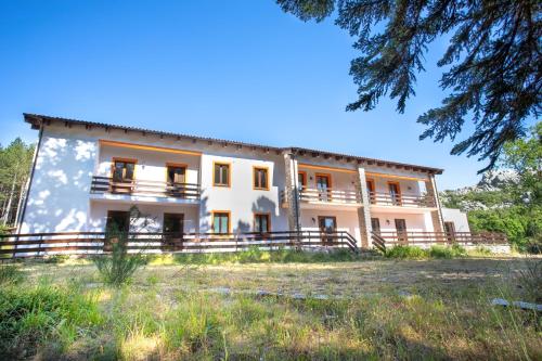 a large house with a fence in front of it at Vallicciola Nature Hotel in Tempio Pausania