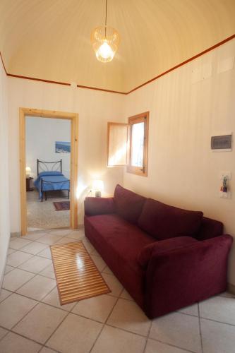 a living room with a red couch and a bedroom at Case Vacanze "Residenze Trapanesi" in Trapani