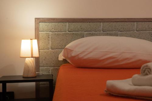 a bed with a pillow and a lamp on a table at Fardella 250 in Trapani