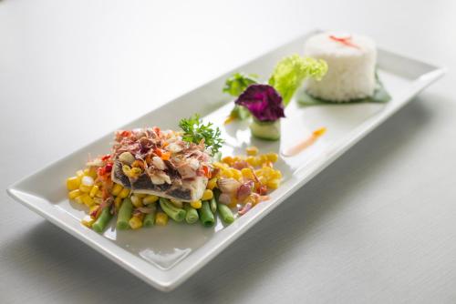 a plate of food with corn and vegetables on it at Brits Hotel Puri Indah in Jakarta