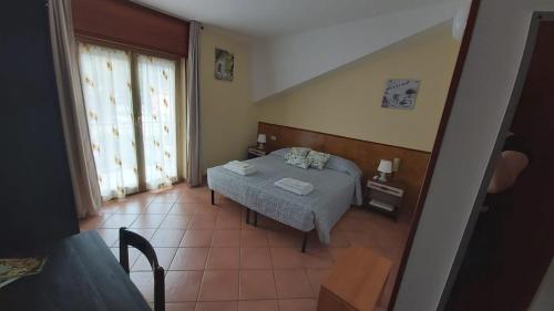 a small bedroom with a bed and a window at Orso Momo in Calizzano