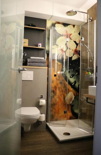 a bathroom with a toilet and a glass shower at Hotel Schmerkötter in Bochum