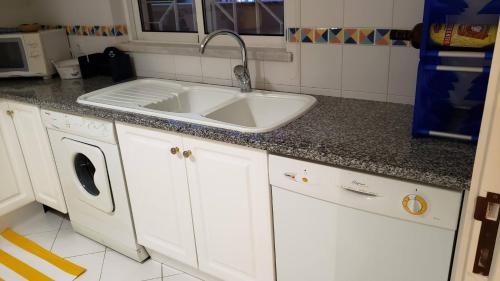 a kitchen with a sink and a washing machine at Marina Vilamoura Apartment in Vilamoura