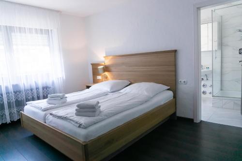 a bedroom with a large bed with towels on it at Eisberg Gästehaus & De Luxe Appartements in Friesenheim