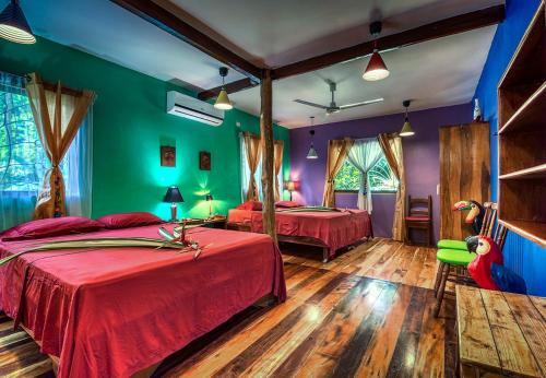 2 camas en una habitación con verde y púrpura en Congo Bongo EcoVillage Costa Rica, en Puerto Viejo