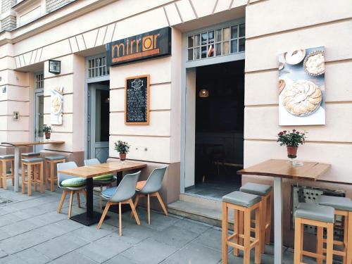 un restaurante con mesas y sillas frente a él en Mirror Pink Studio Apartment, en Cracovia