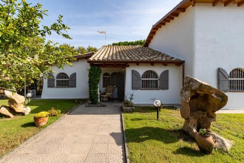a white house with a rock in front of it at Casa Stella Di Madel in Flumini di Quartu