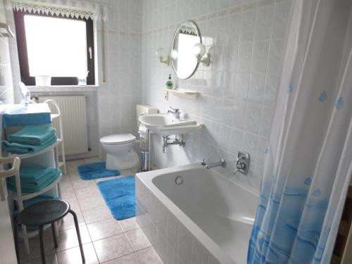 een badkamer met een bad, een wastafel en een toilet bij Ferienwohnung Haus Sonnenschein in Trassem