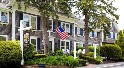 a house with an american flag in front of it at Queen Anne Inn in Chatham